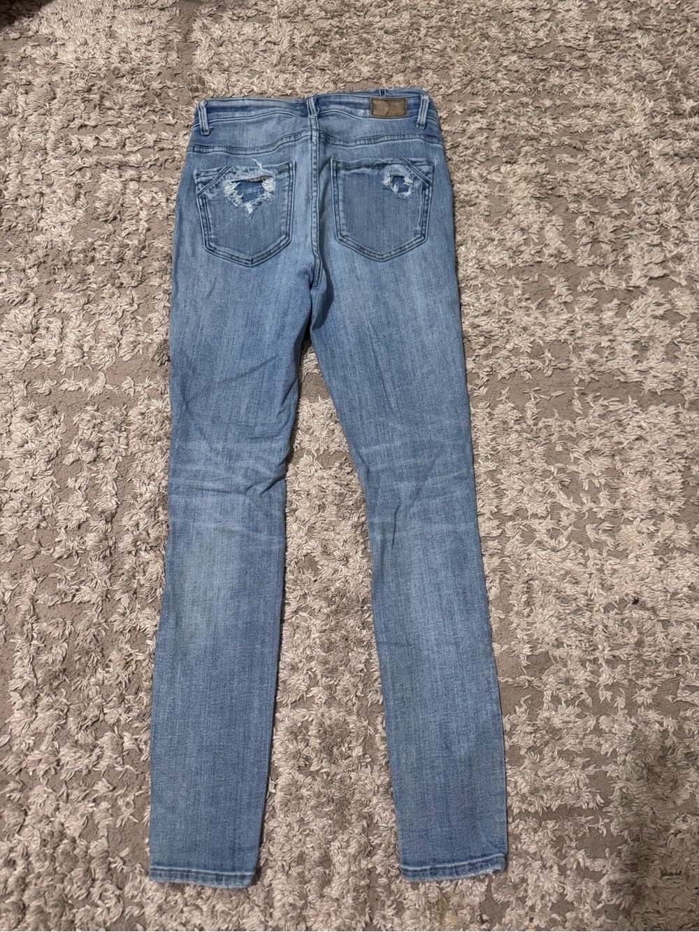 Buckle Light Blue Skinny Jeans with Distressed Back Pockets
